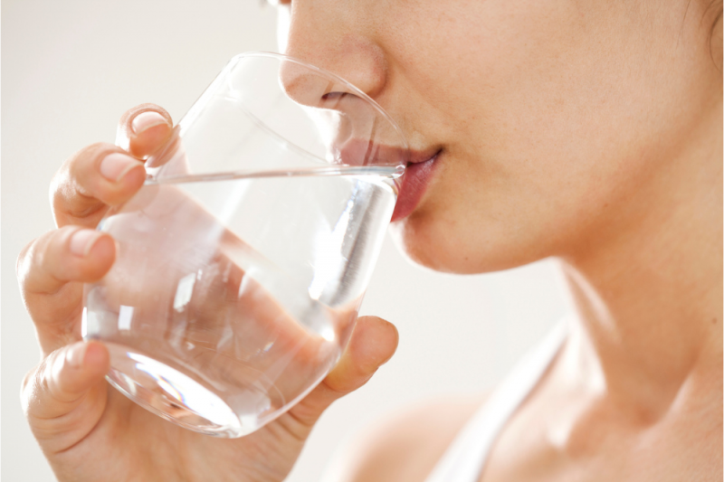 A woman drinks a cool glass of water