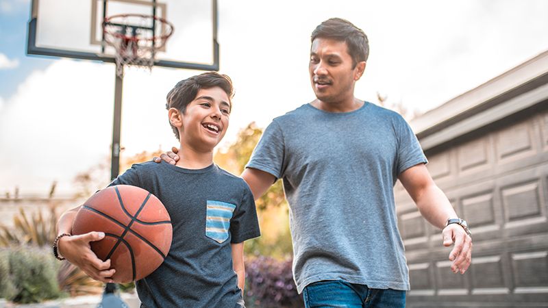 Father and son chatting on a basketball court