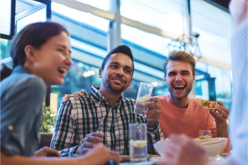 Three friends smile and drink glasses of water