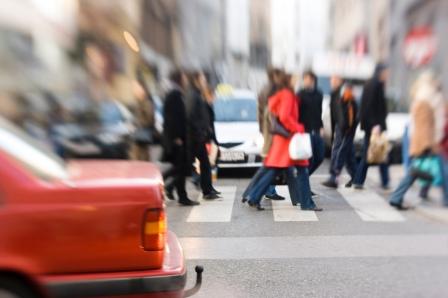 A large group of people crossing a busy street