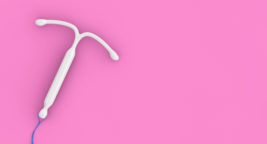 A photograph of a white t-shaped hormonal iud implant device