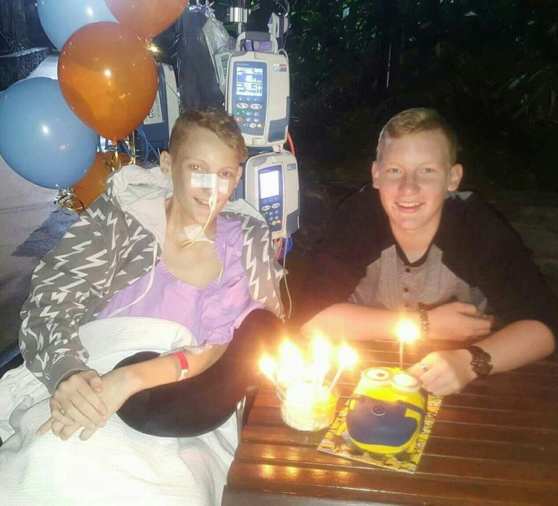 A picture of Jordan and his brother with a birthday cake.