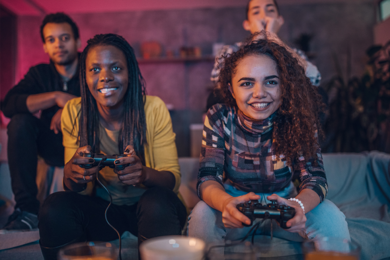 Four friends on a couch playing video games