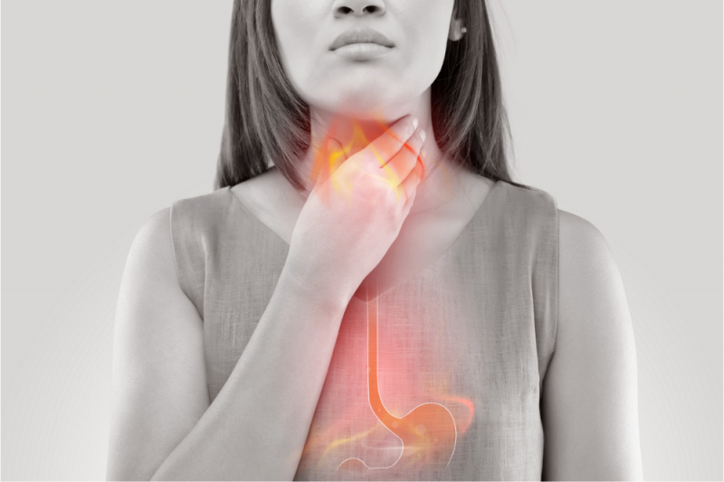 A photo of a woman holding her throat with a graphic of a stomach, oesophagus, throat, larynx or voice box superimposed in orange