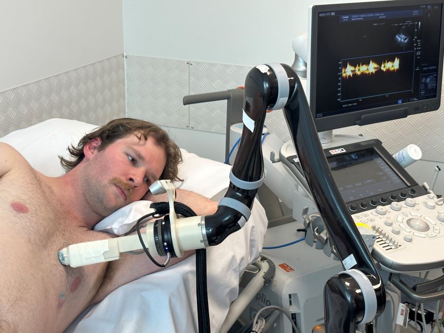 The robotic cardiac ultrasound scans a patient.