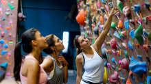 Three young woman looking at the routes on an indoor rock climbing wall