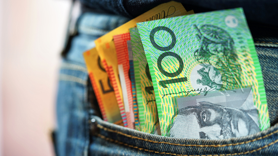 A photo of a variety of Australian currency bills sticking out of a jeans pocket