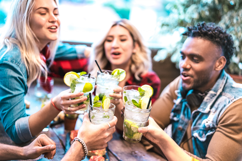 A group of four people toasting each other with zero alcohol mocktails