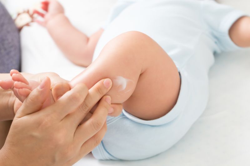 Baby getting sunscreen applied