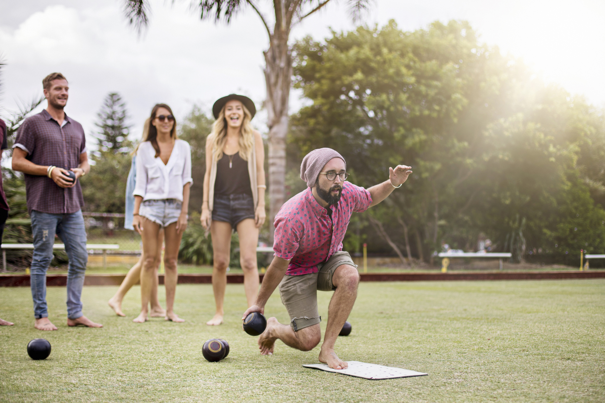 Friends having fun doing barefoot lawn bowls