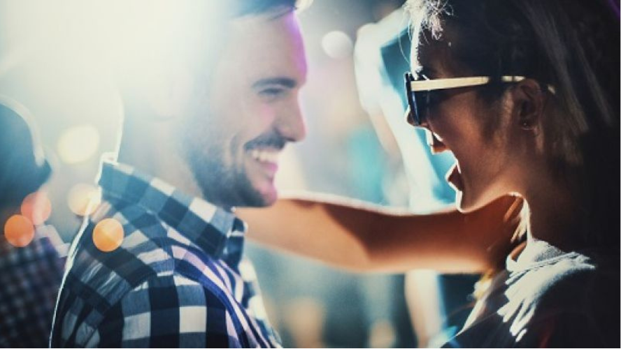 A photo of a man and woman smiling at each other