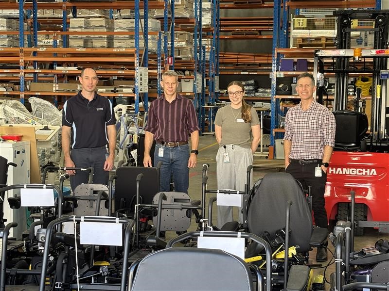 Image of James, Nick, Annie and Mick in warehouse with MASS stock devices in front of them.