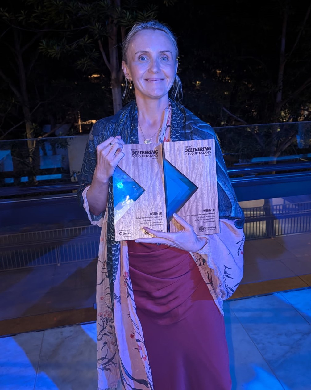 A woman stands with her award