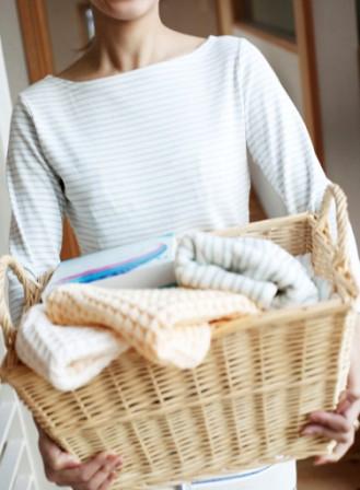 lady holding a basket of clean laundry