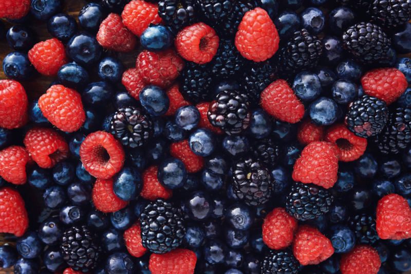 A colourful mix of blueberries raspberries and blackberries photographed from above