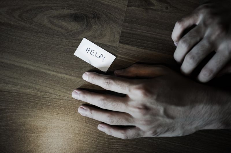 Hands with a note that says help