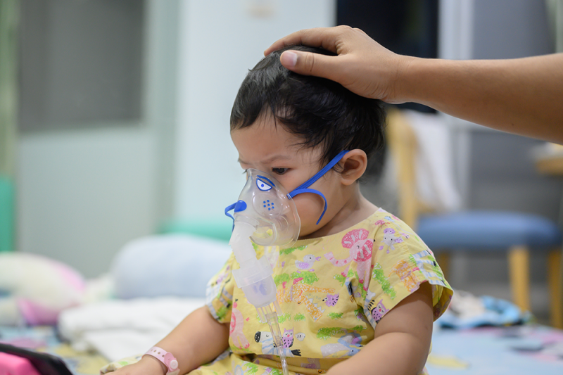 A little girl sick with RSV receiving oxygen in hospital through a mask
