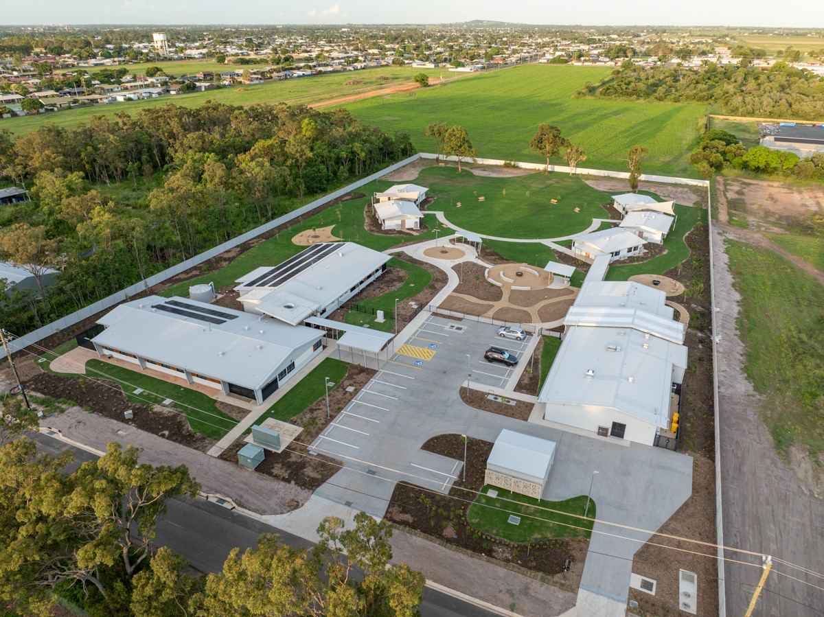 Aerial image of buildings with a carpark between and gardens around. 