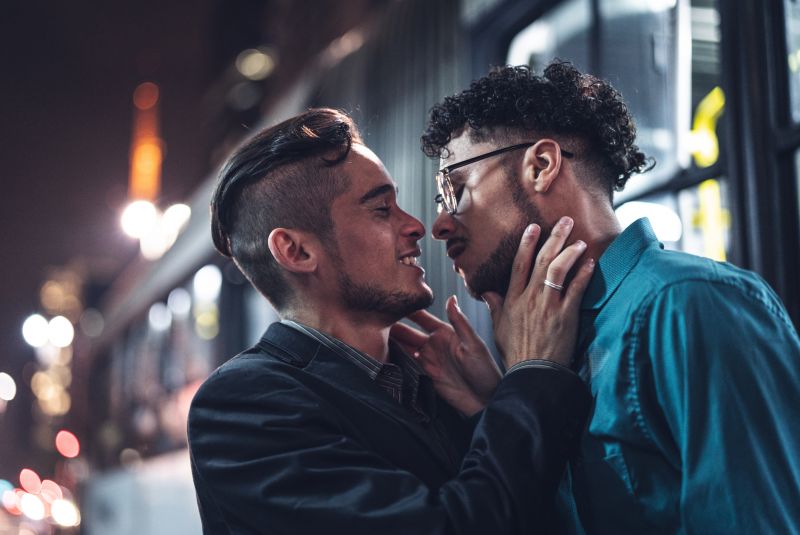 Two men lean in to kiss.