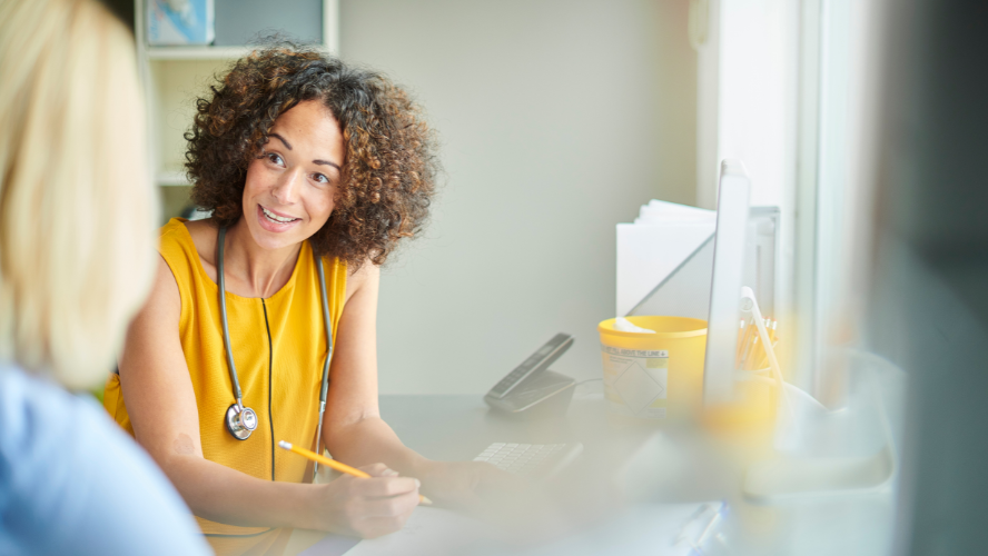 A doctor in a yellow shirt is speaking to her patient