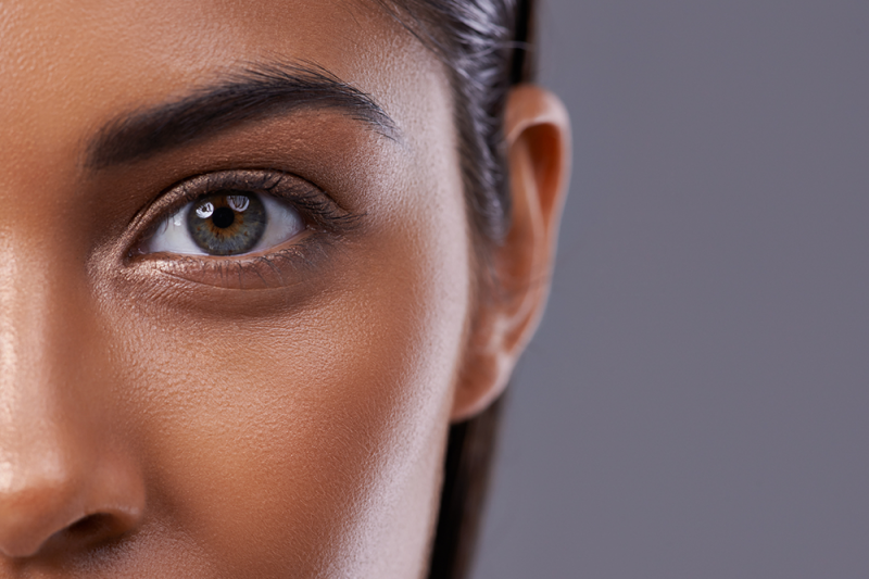 A close up of a woman's face showing her beautiful hazel eyes