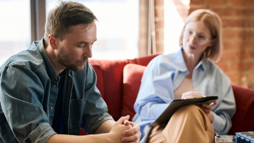 A man sits on the couch with his psychologist