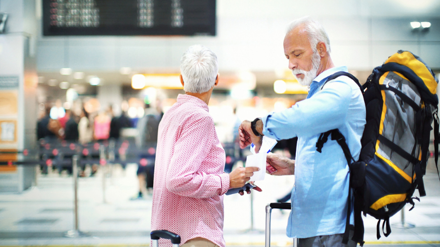 A stressed looking couple check the time of their flight at the departure hall of the airport