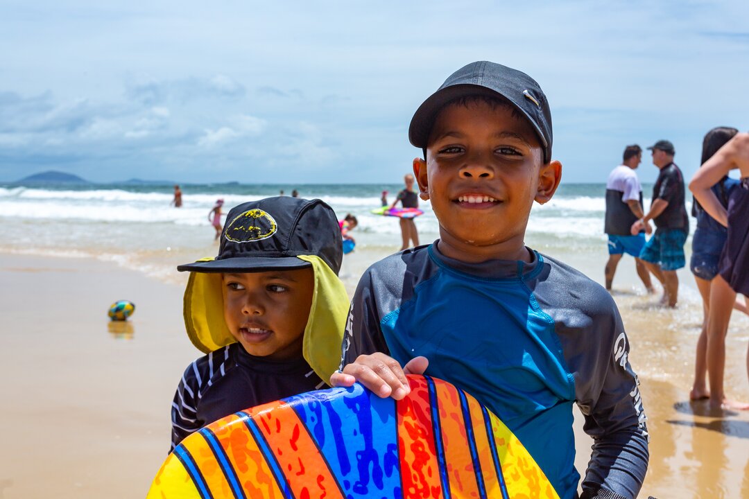 Young, sun safe brothers at the beach enjoying Queensland's weather and being active outdoors.