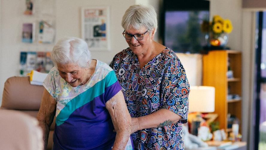 A carer gently guides a dementia patient