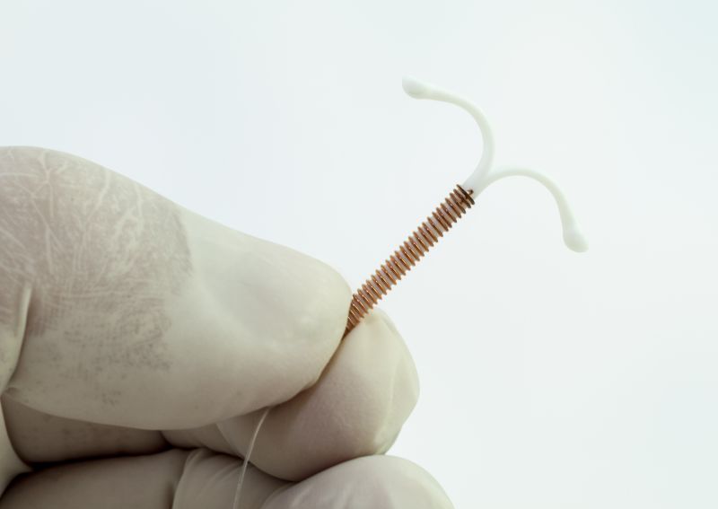 An IUD held in a gloved hand.
