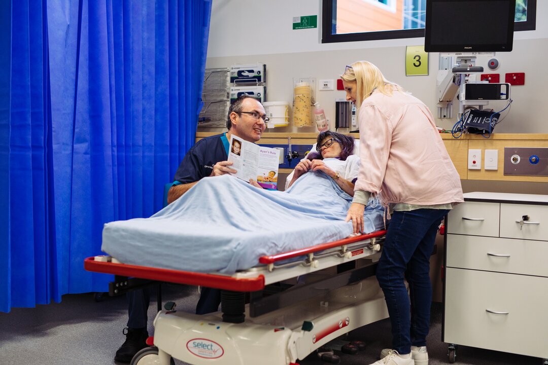A nurse going through the Ryan's Rule brochure with a patient and their mother.