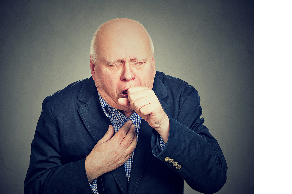 An older man in a jacket coughing