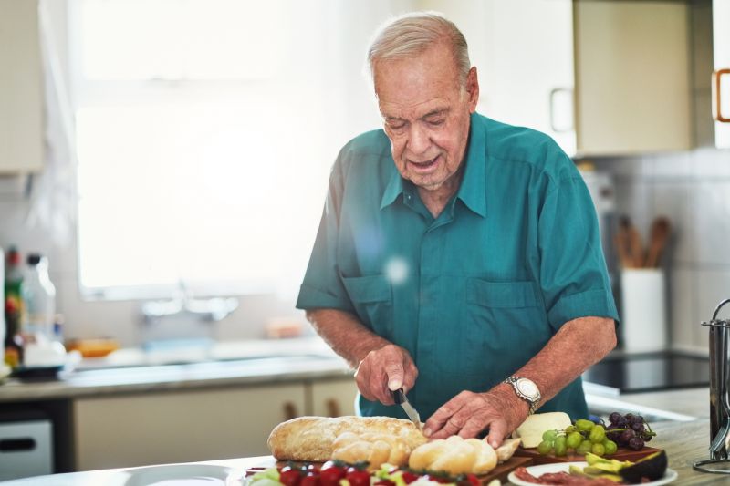 Older man preparing food in his kitchen