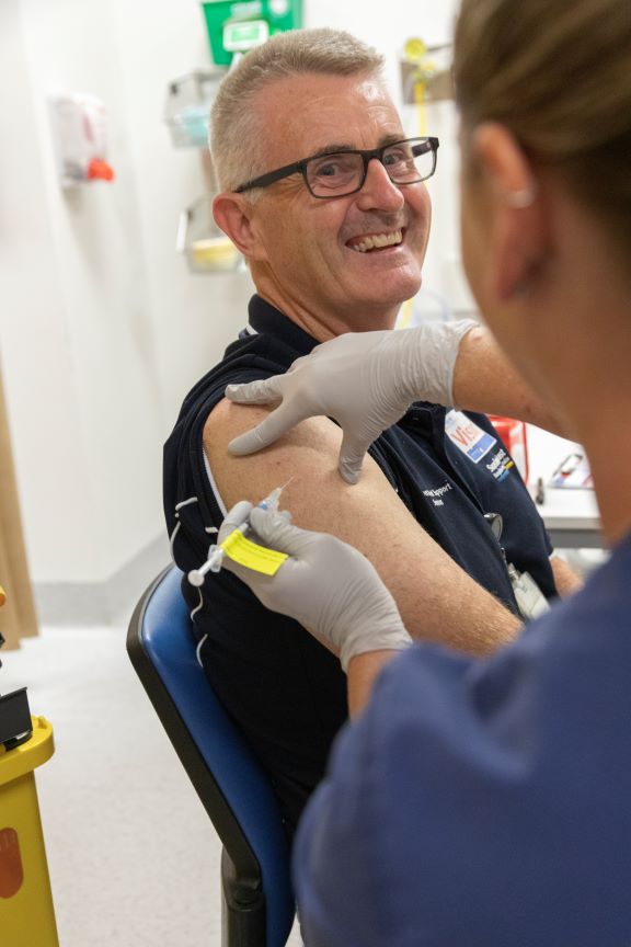 A Queensland Health staff member receives a COVID-19 vaccination.