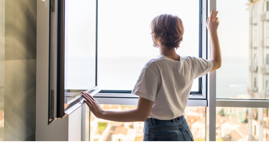 A woman gazes out of an open window