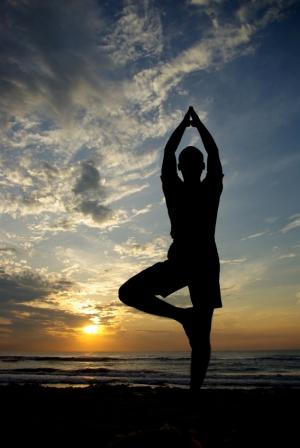 person in a yoga pose on the beach