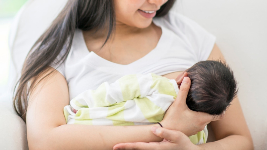 A mother breastfeeds her newborn baby