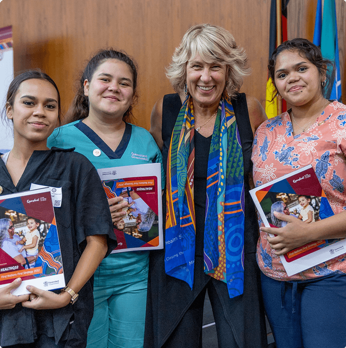 Haylene Grogan, Queensland Health&rsquo;s Chief First Nations Health Officer, standing with three staff members at the First Nations First Strategy launch event, all smiling and holding copies of the strategy document.