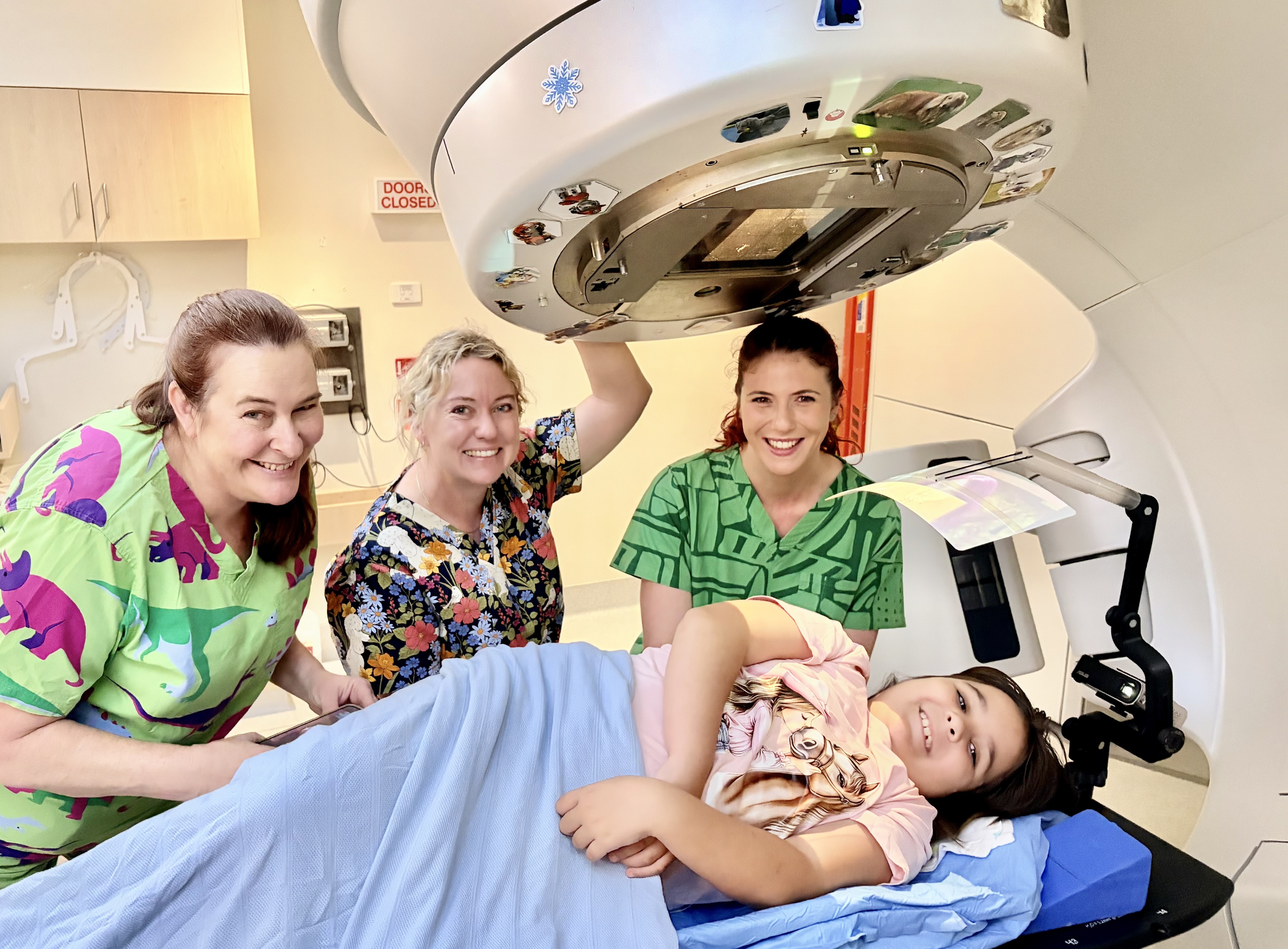 Nine-year-old Connie getting ready to watch her favourite show while undergoing radiation treatment.    L-R: Aimee Welch, Narelle Wallace and Jodi Mitchell.