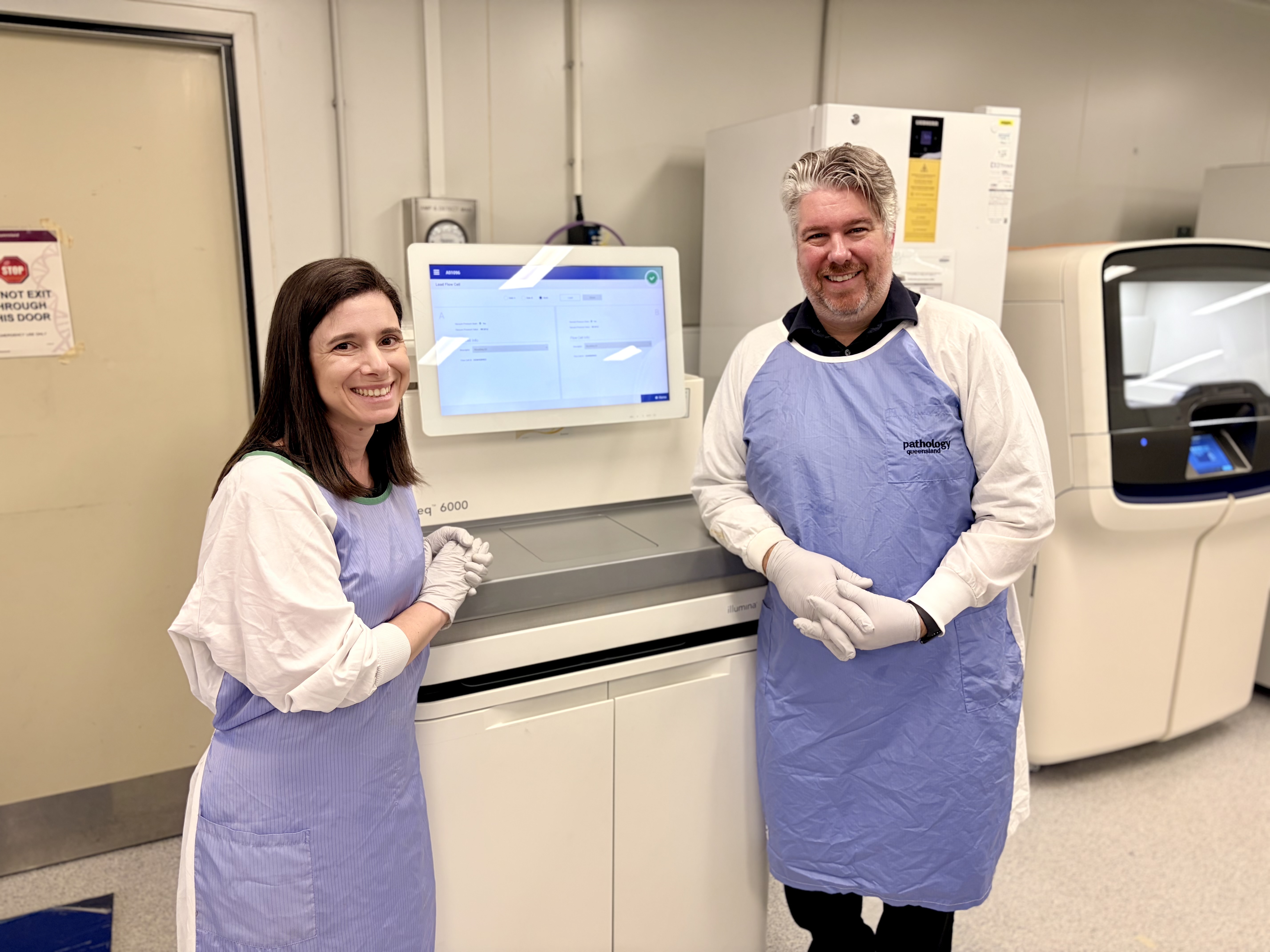 UQ's Dr Tatiana Yanes and Pathology Queensland's Ben Lundie with the Novaseq 6000 sequencer which enables genetic testing to be conducted in Queensland.